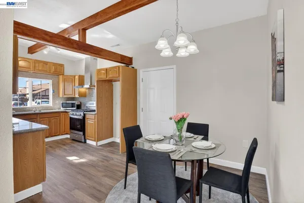 a view of a dining room with furniture a chandelier and wooden floor