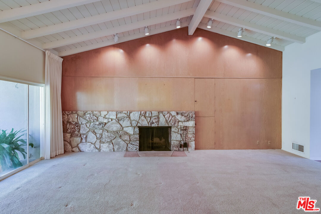 642 Elkins Road Los Angeles, CA 90049 - Photo 3 of 31 a view of empty room with fireplace and fan