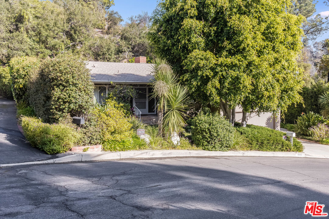 642 Elkins Road Los Angeles, CA 90049 - Photo 27 of 31 a view of house with a yard and potted plants