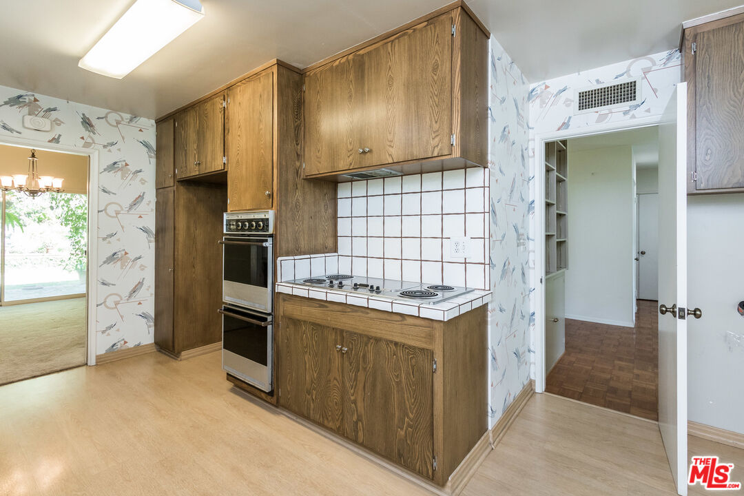 642 Elkins Road Los Angeles, CA 90049 - Photo 8 of 31 a kitchen with stainless steel appliances granite countertop a stove and a refrigerator