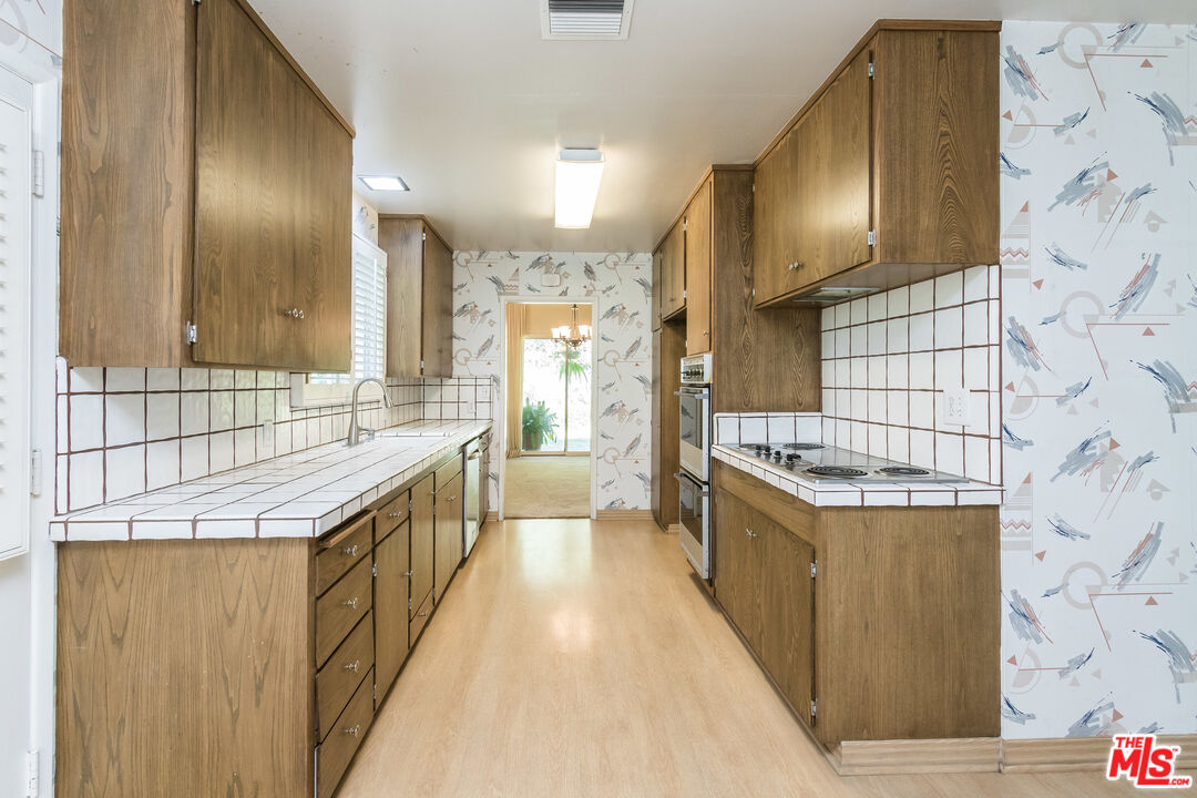 642 Elkins Road Los Angeles, CA 90049 - Photo 10 of 31 a bathroom with a granite countertop double vanity and a sink