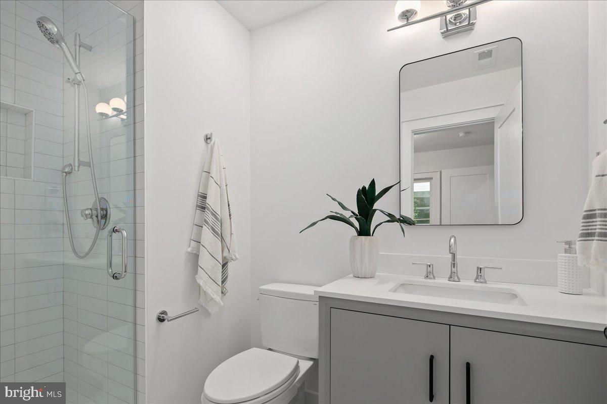 909 North Irving Street Arlington, VA 22201 - Photo 15 of 69 a bathroom with a toilet sink shower and mirror