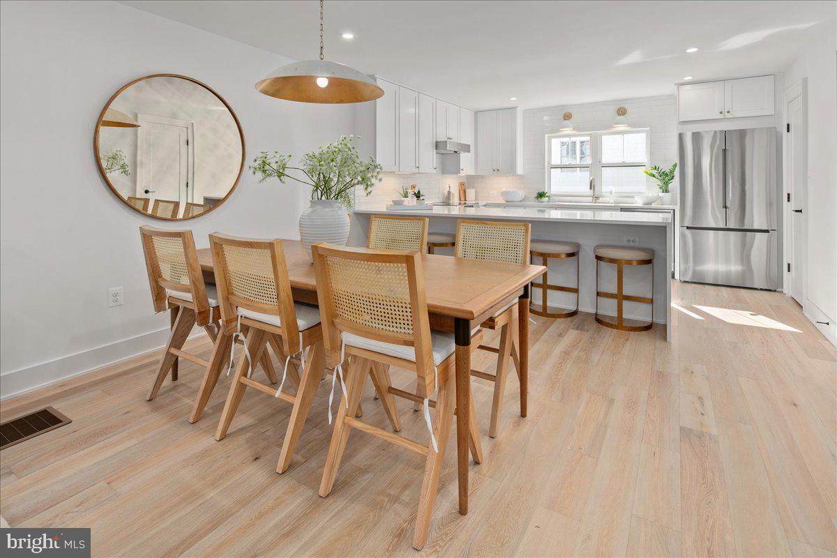 909 North Irving Street Arlington, VA 22201 - Photo 20 of 69 a dining room with wooden floor a chandelier a wooden table and chairs