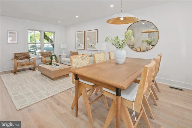 a kitchen with stainless steel appliances granite countertop a table chairs refrigerator and sink