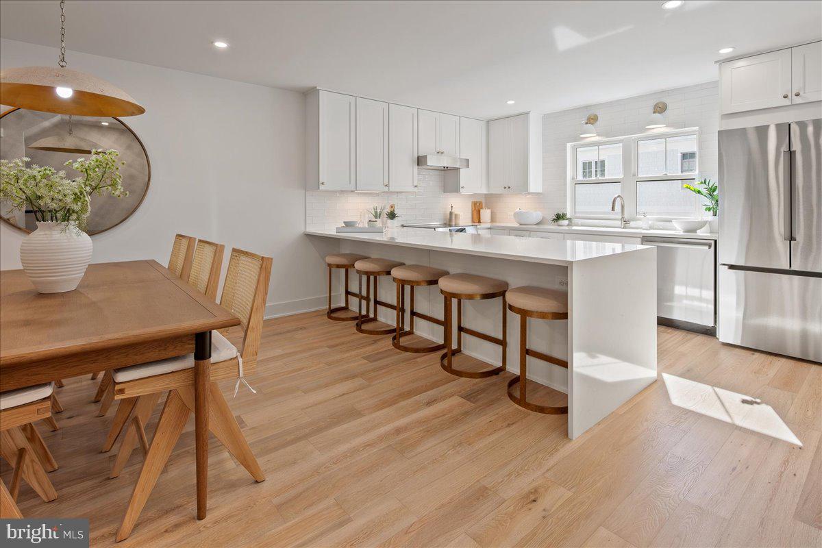 909 North Irving Street Arlington, VA 22201 - Photo 23 of 69 a kitchen with stainless steel appliances granite countertop a dining table chairs and view of living room