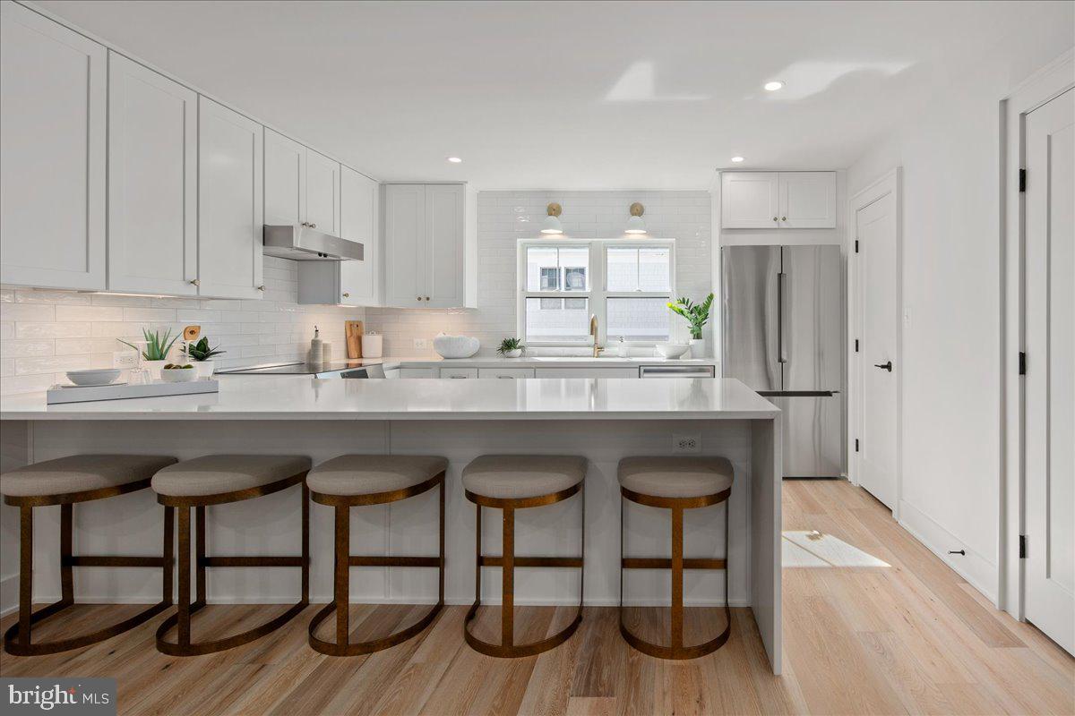 909 North Irving Street Arlington, VA 22201 - Photo 25 of 69 a kitchen with granite countertop a sink cabinets and wooden floor