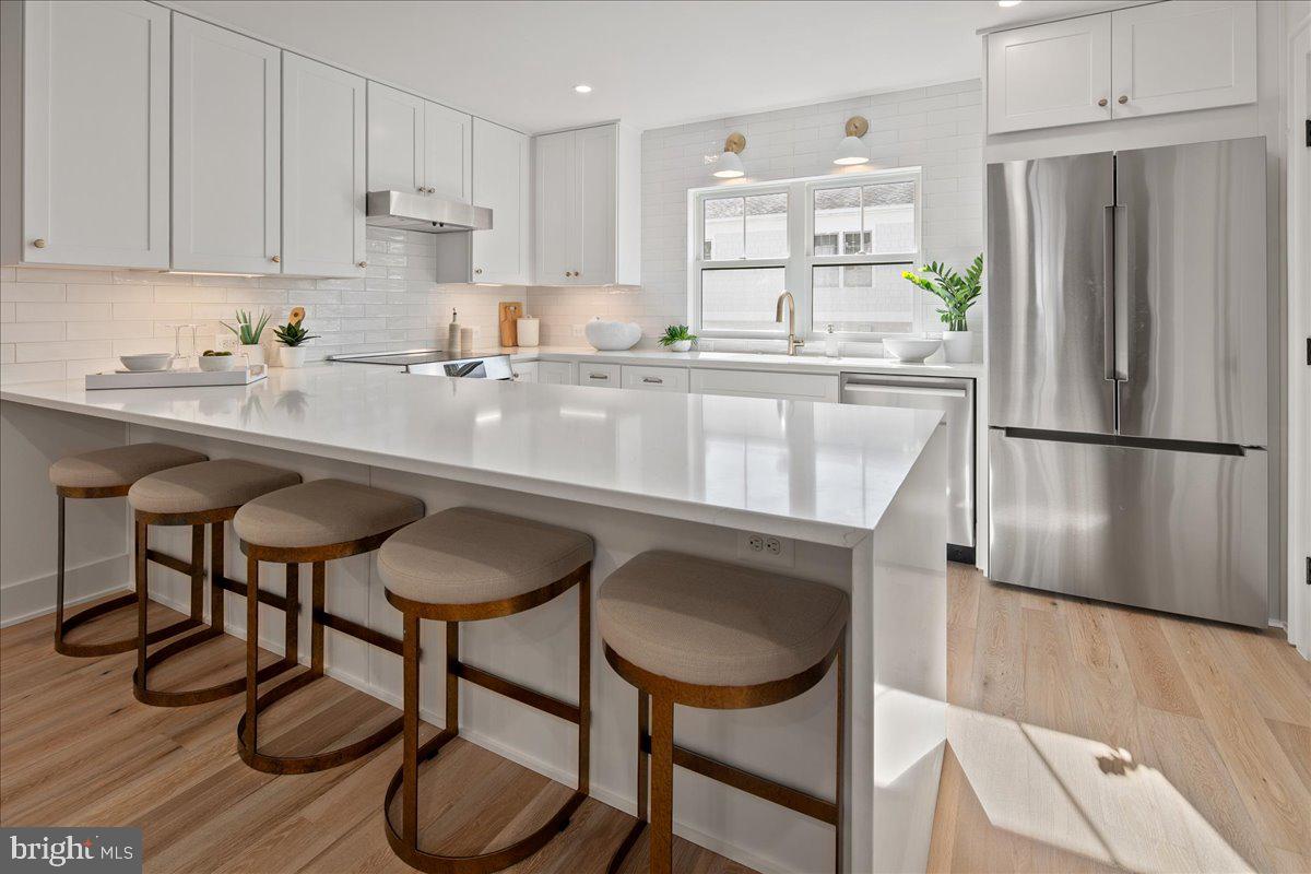 909 North Irving Street Arlington, VA 22201 - Photo 26 of 69 a kitchen with stainless steel appliances granite countertop a table chairs refrigerator and sink