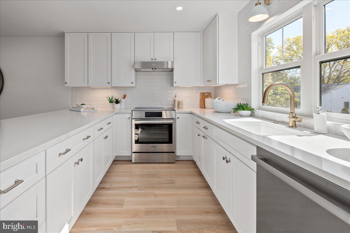 909 North Irving Street Arlington, VA 22201 - Photo 28 of 69 a kitchen with white cabinets sink and window