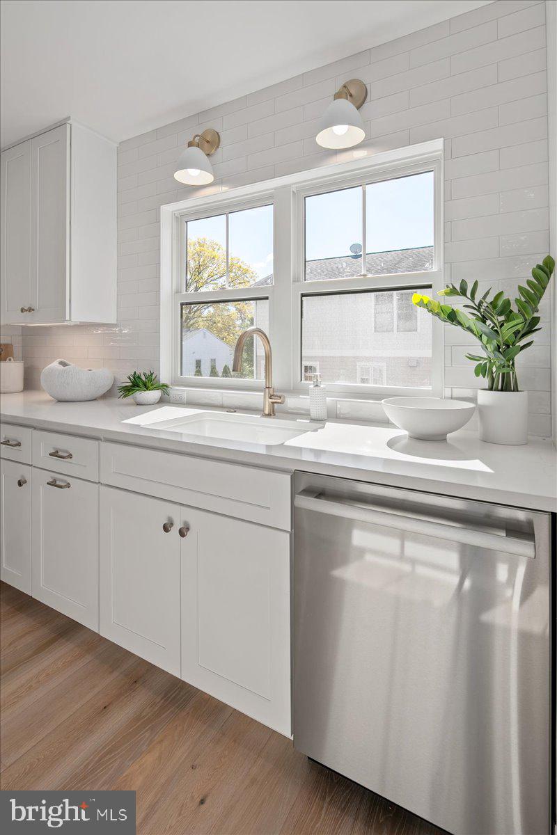 909 North Irving Street Arlington, VA 22201 - Photo 30 of 69 a kitchen with stainless steel appliances granite countertop a sink a window and cabinets