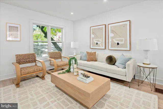 a living room with furniture a table and a large mirror next to a window