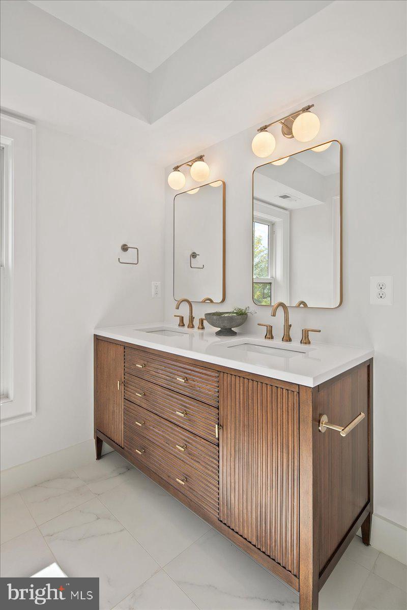 909 North Irving Street Arlington, VA 22201 - Photo 52 of 69 a bathroom with a double vanity sink and a mirror