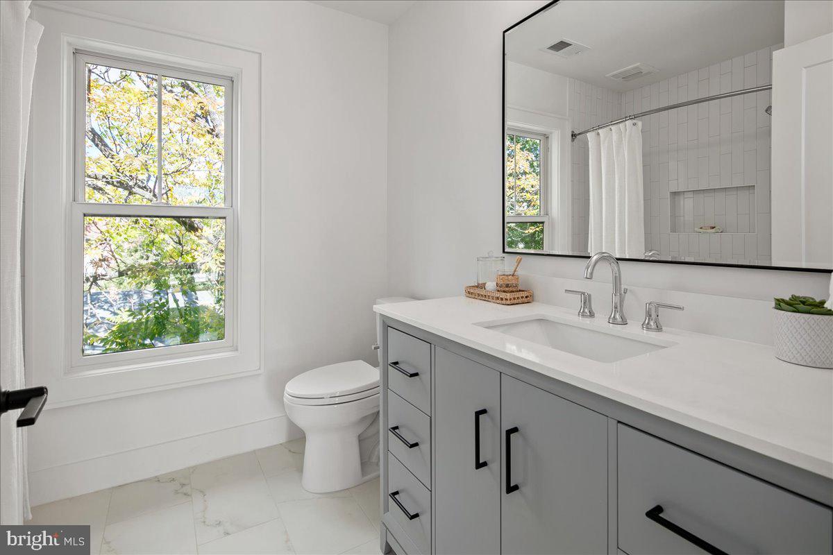 909 North Irving Street Arlington, VA 22201 - Photo 64 of 69 a bathroom with a granite countertop toilet sink and mirror