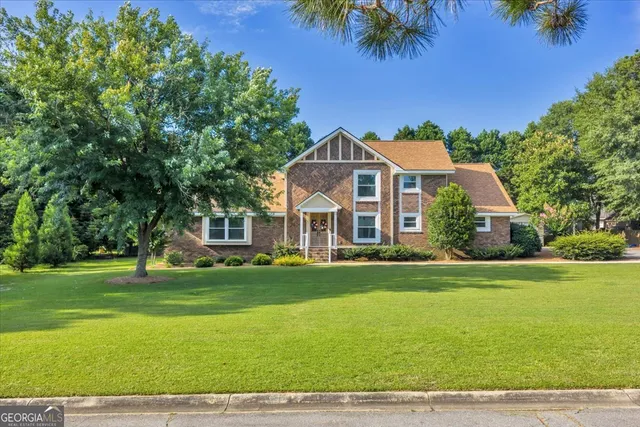 an aerial view of a house with a garden and swimming pool