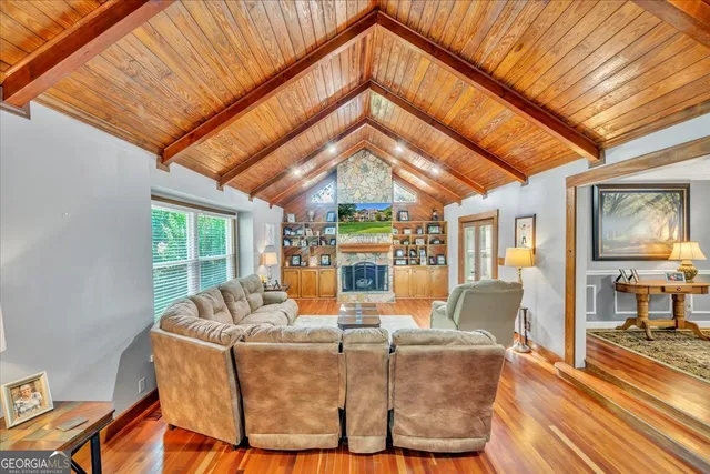 a living room with fireplace furniture and a large window