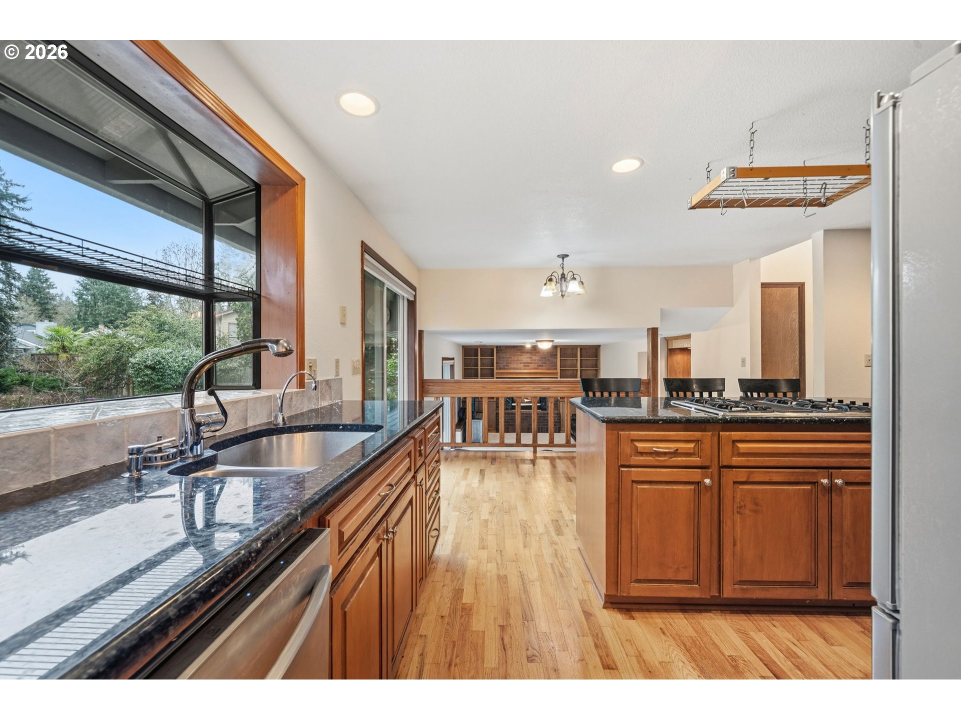 13825 Southwest Weir Road Beaverton, OR 97008 - Photo 11 of 40 a living room with stainless steel appliances granite countertop a sink a counter space and a large window