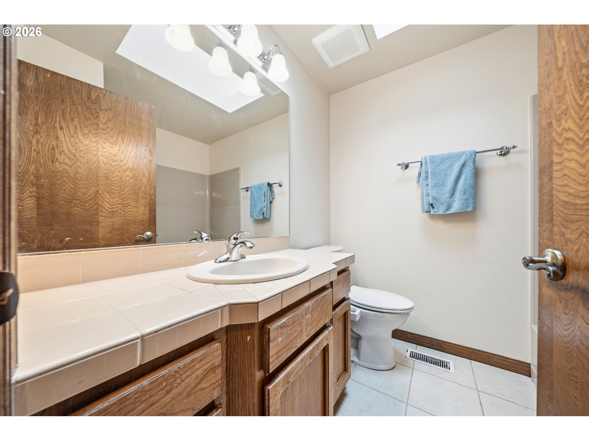 13825 Southwest Weir Road Beaverton, OR 97008 - Photo 22 of 40 a bathroom with a sink a toilet and mirror