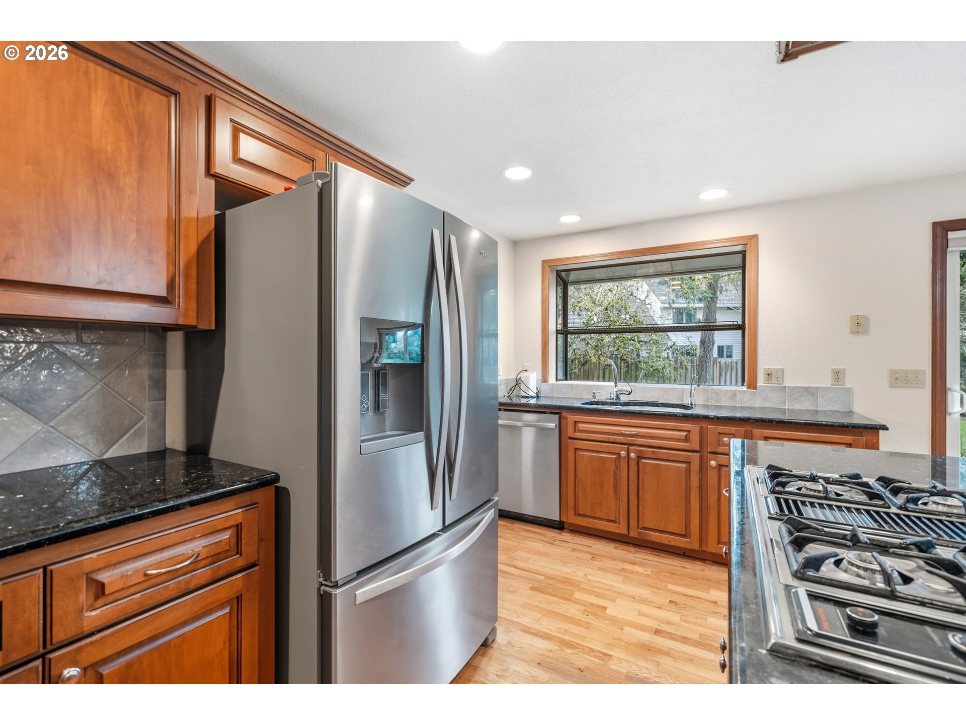 13825 Southwest Weir Road Beaverton, OR 97008 - Photo 10 of 40 a kitchen with stainless steel appliances granite countertop a refrigerator and a stove top oven