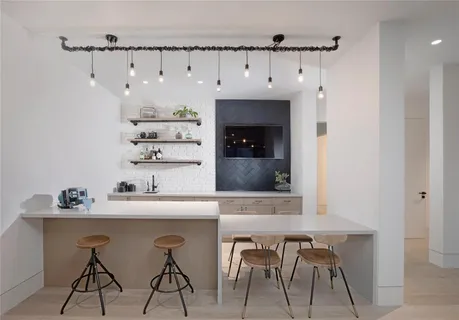 a view of a hallway with wooden floor and a bathroom