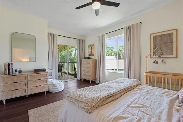 a view of an empty room with wooden floor and a ceiling fan