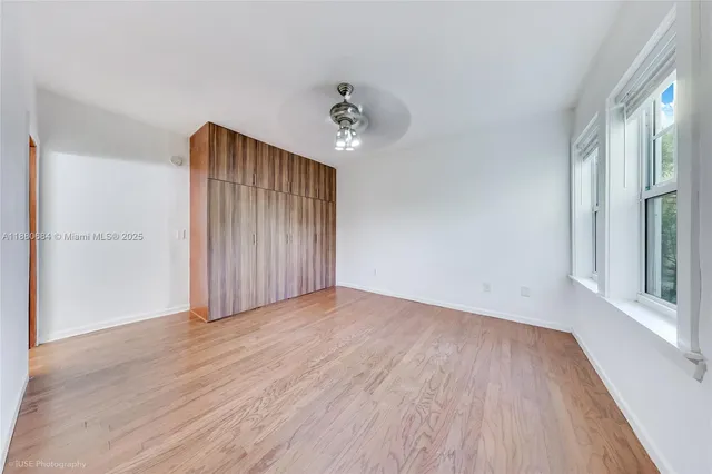 wooden floor in an empty room with a window
