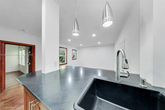 a view of a kitchen with kitchen island a sink stainless steel appliances and cabinets