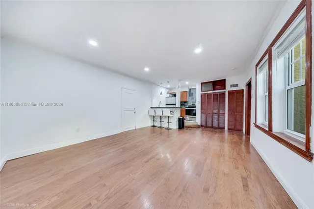 a view of empty room with wooden floor and window