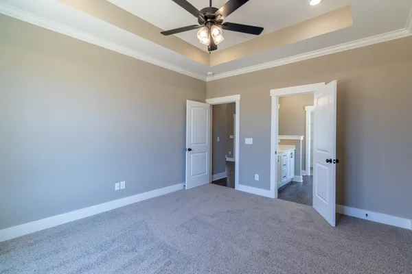 an empty room with closet and a chandelier fan