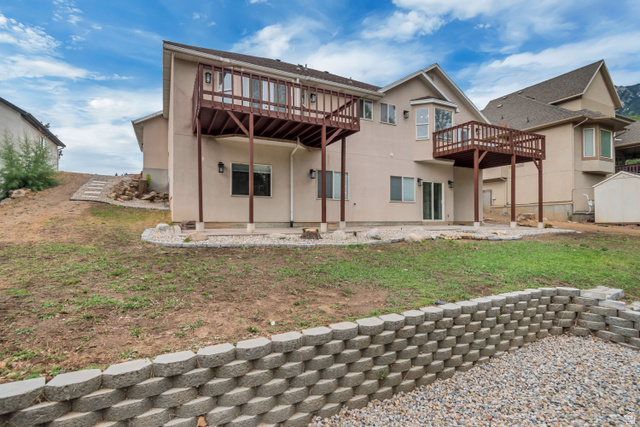 2154 Wasatch Boulevard Sandy, UT 84092 - Photo 33 of 55 Back of house with a patio, stucco siding, a deck, and a yard