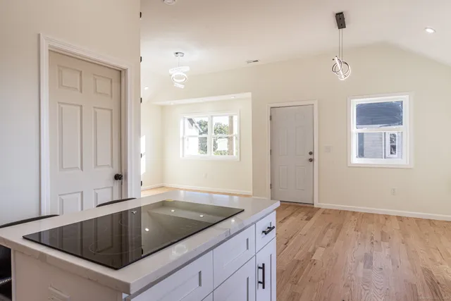 a kitchen with white cabinets and a window