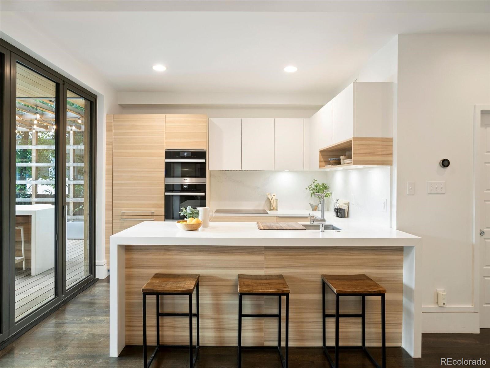 1253 Elizabeth Street Denver, CO 80206 - Photo 13 of 49 a kitchen with a table chairs sink and cabinets