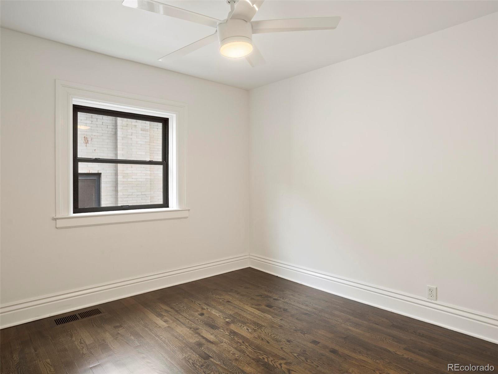 1253 Elizabeth Street Denver, CO 80206 - Photo 31 of 49 an empty room with wooden floor and windows