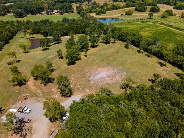 an aerial view of residential houses with outdoor space and trees