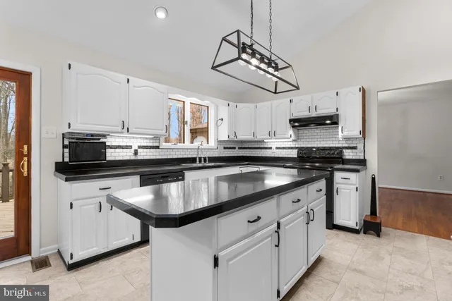 a kitchen with stainless steel appliances kitchen island granite countertop a sink and cabinets