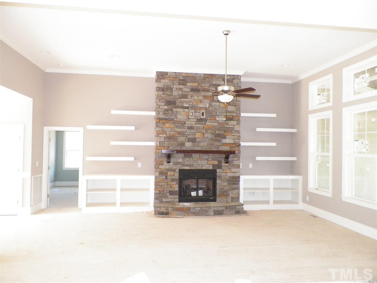 6113 Spring Branch Circle Raleigh, NC 27603 - Photo 6 of 22 a living room with a fireplace furniture a ceiling fan and a window
