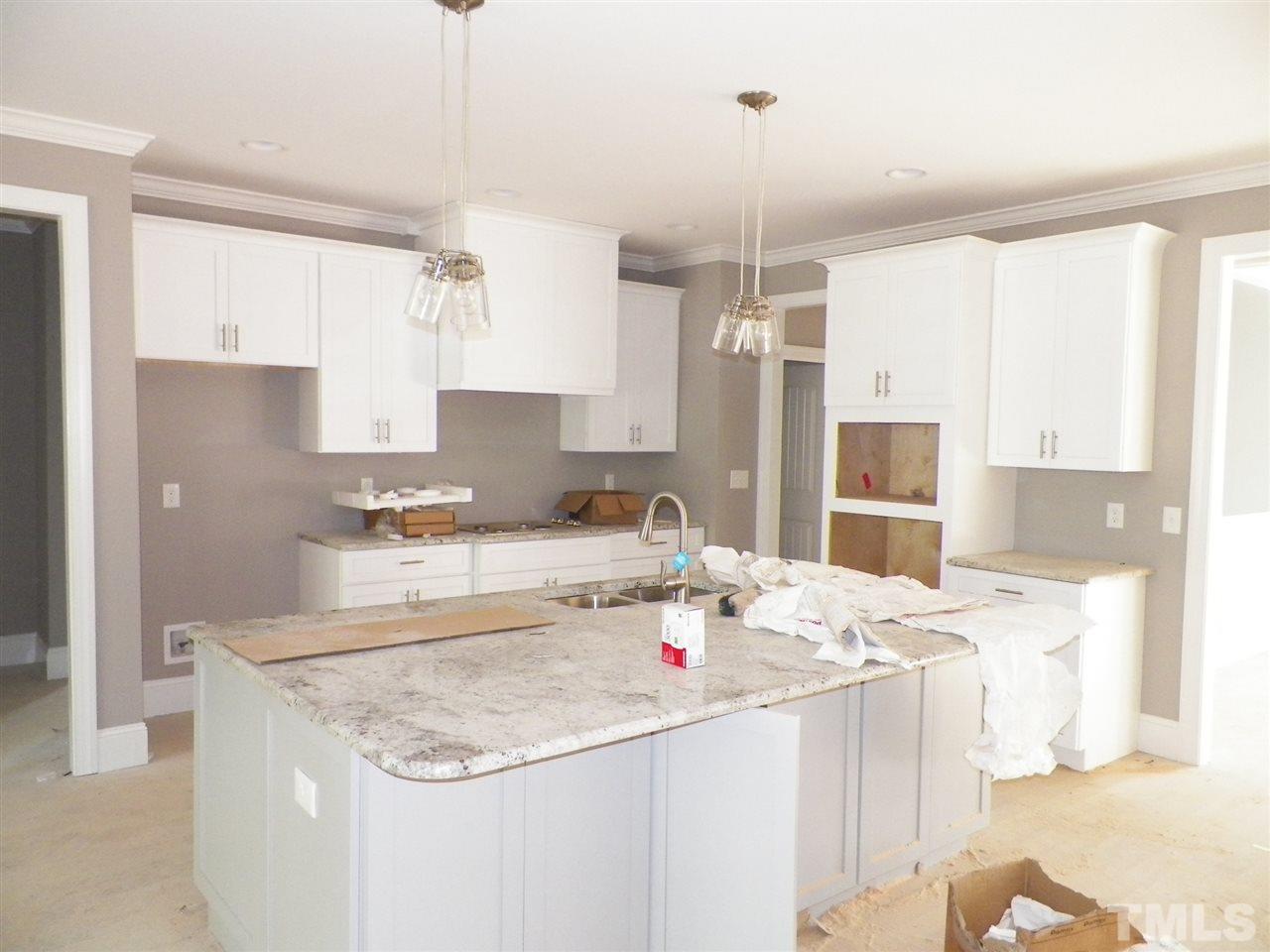 6113 Spring Branch Circle Raleigh, NC 27603 - Photo 7 of 22 a kitchen with stainless steel appliances kitchen island granite countertop a sink and refrigerator
