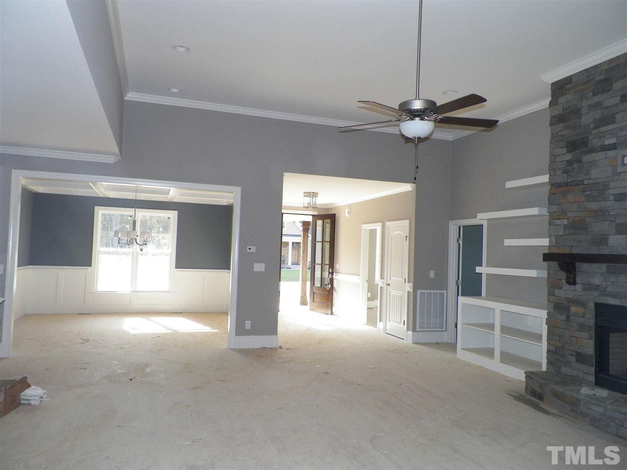 6113 Spring Branch Circle Raleigh, NC 27603 - Photo 10 of 22 a view of a livingroom with a fireplace a ceiling fan and windows