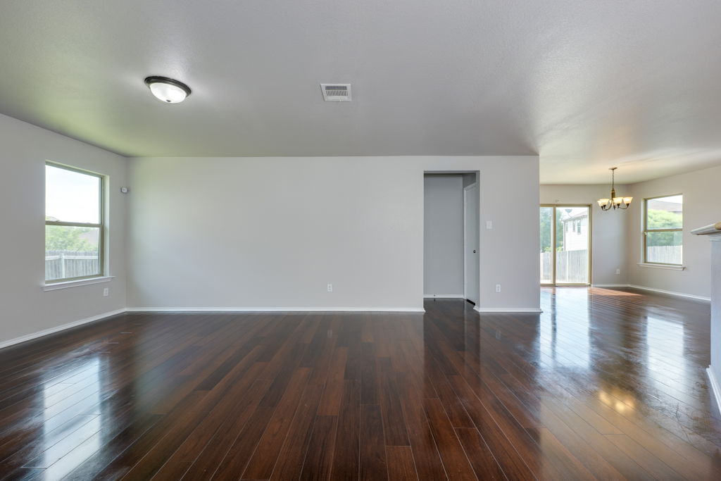 210 Cushman Drive Kyle, TX 78640 - Photo 3 of 21 Expansive living area with wood-finish flooring and light gray painted walls