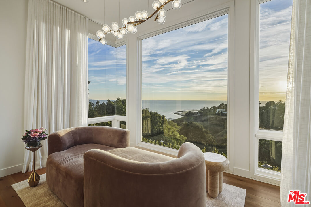 3140 Sweetwater Mesa Road Malibu, CA 90265 - Photo 41 of 71 a living room with furniture a chandelier and a large window