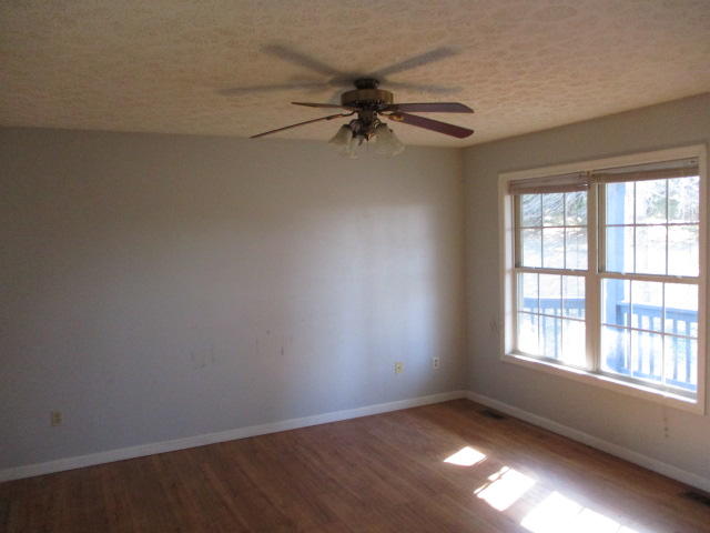 9739 Stewartsville Road Goodview, VA 24095 - Photo 2 of 11 an empty room with windows and fan