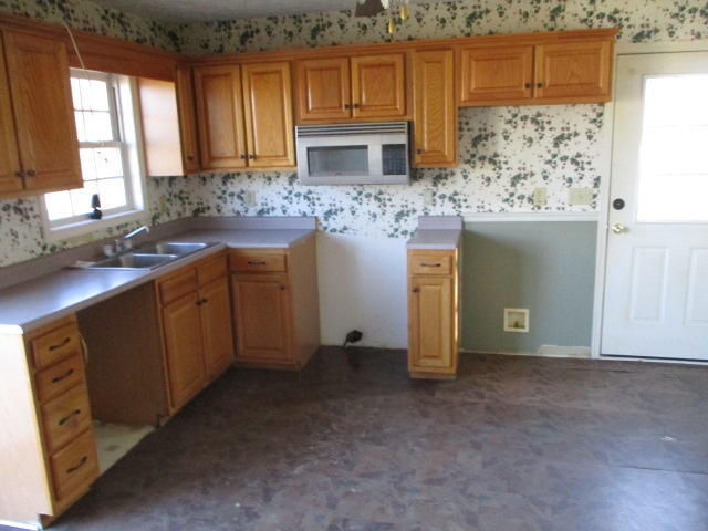 9739 Stewartsville Road Goodview, VA 24095 - Photo 4 of 11 a kitchen with stainless steel appliances granite countertop a sink a stove and a refrigerator