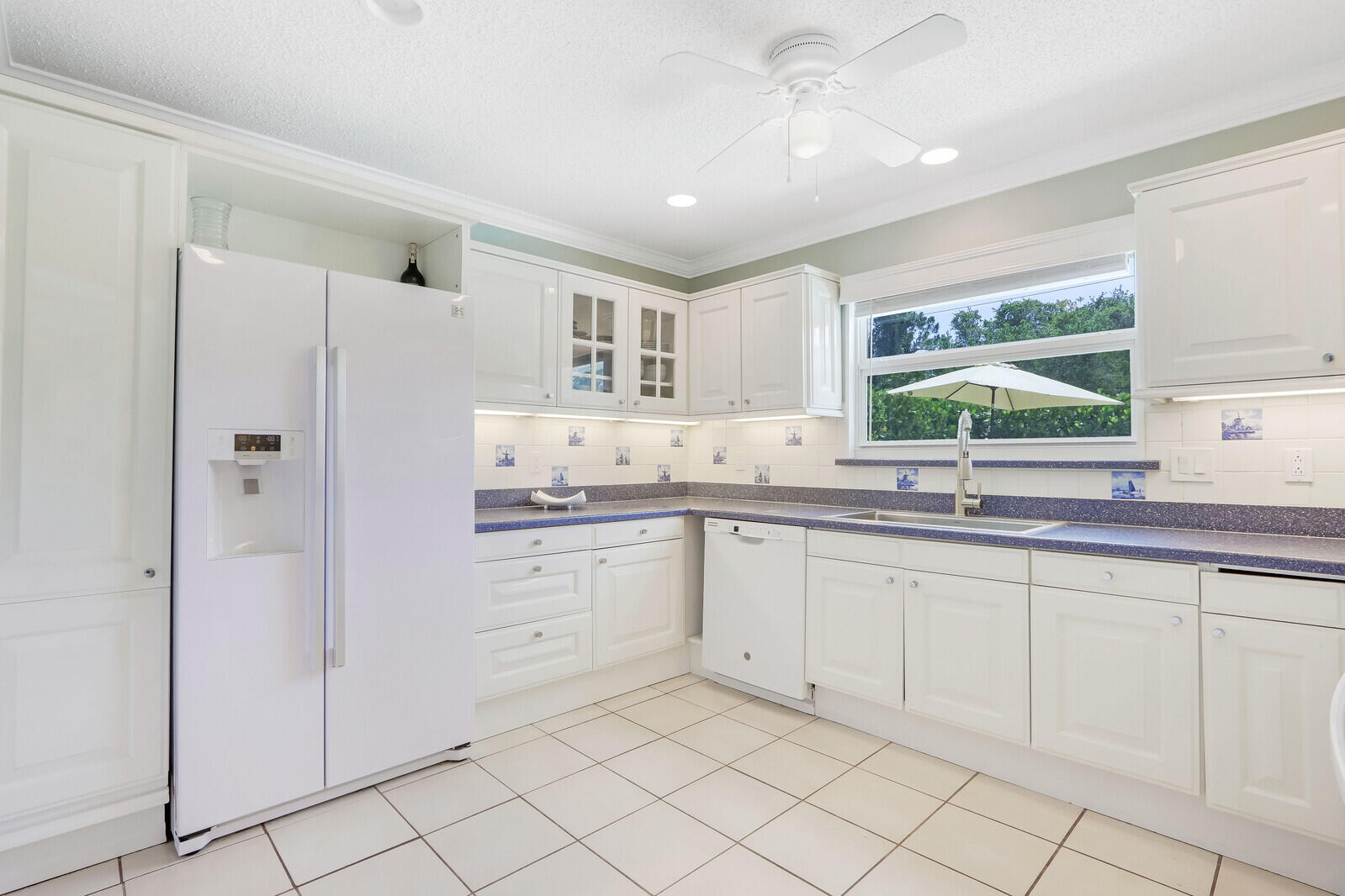 6009 Eagles Nest Drive Jupiter, FL 33458 - Photo 13 of 49 a kitchen with white cabinets and a sink