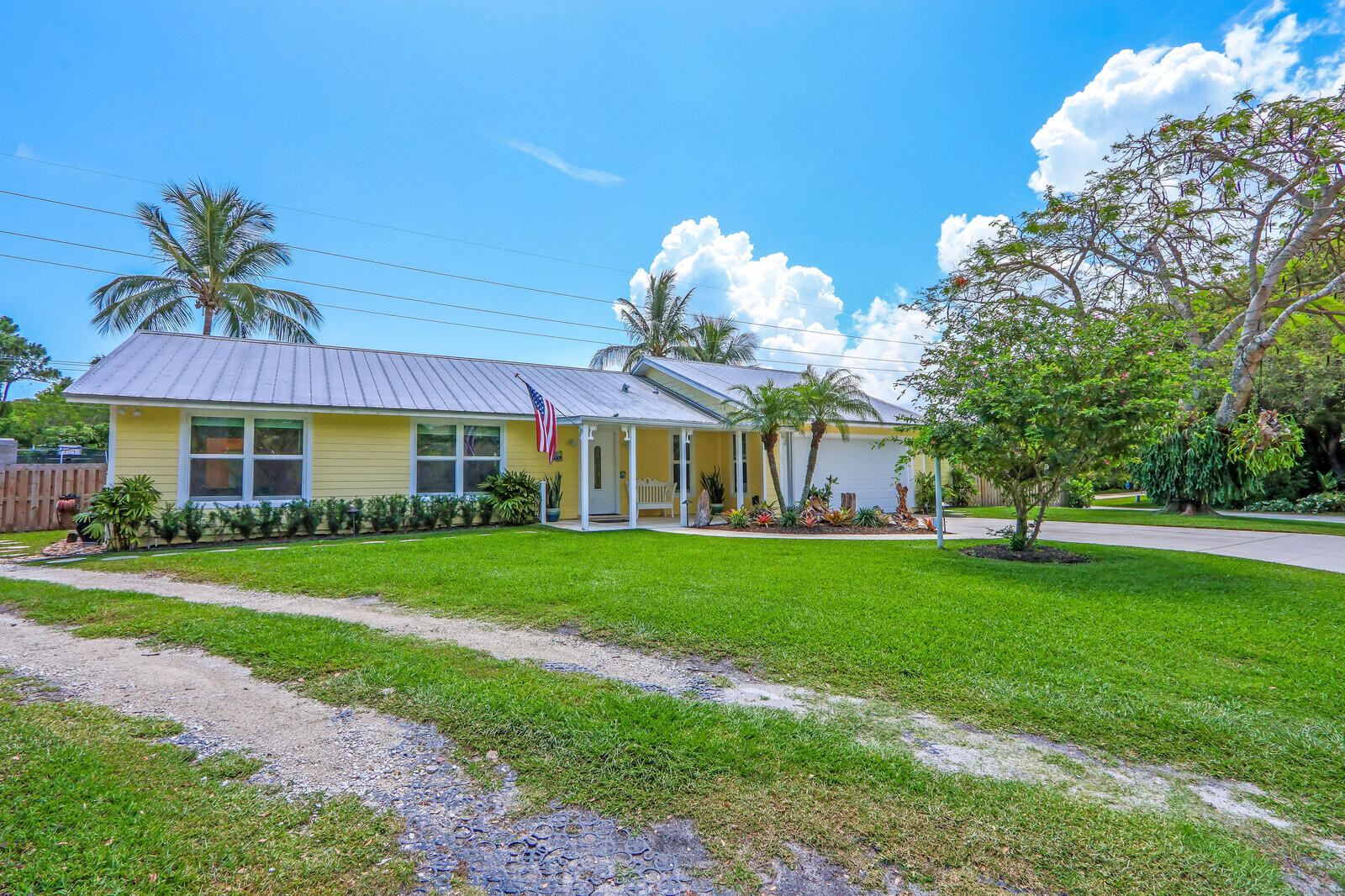6009 Eagles Nest Drive Jupiter, FL 33458 - Photo 4 of 49 a front view of a house with a garden