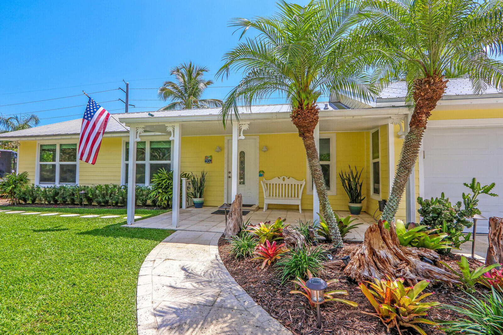 6009 Eagles Nest Drive Jupiter, FL 33458 - Photo 6 of 49 a front view of a house with a garden