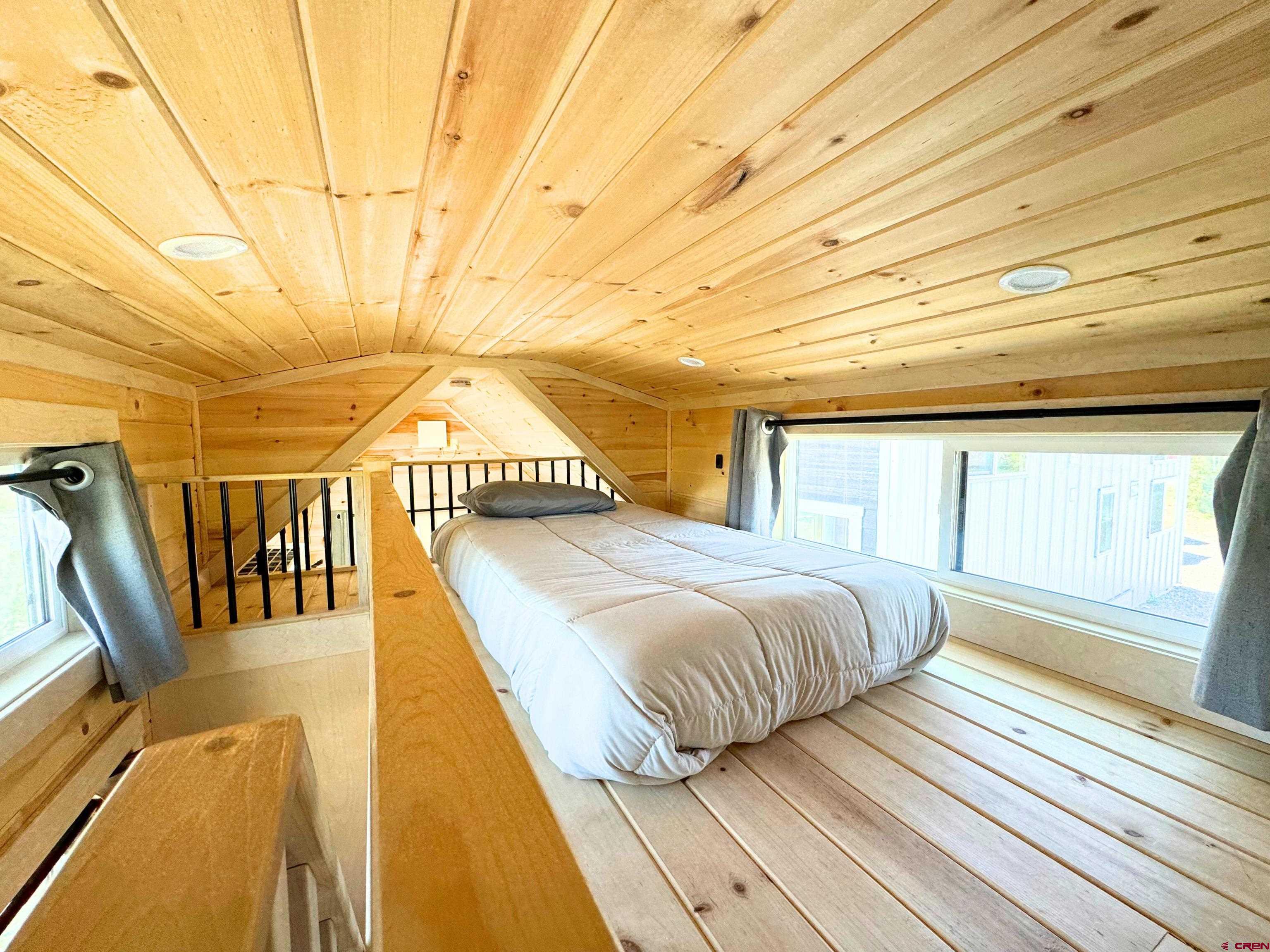 22130 6850 Road, Unit 210 Montrose, CO 81403 - Photo 17 of 35 a bedroom with a bed and wooden floor