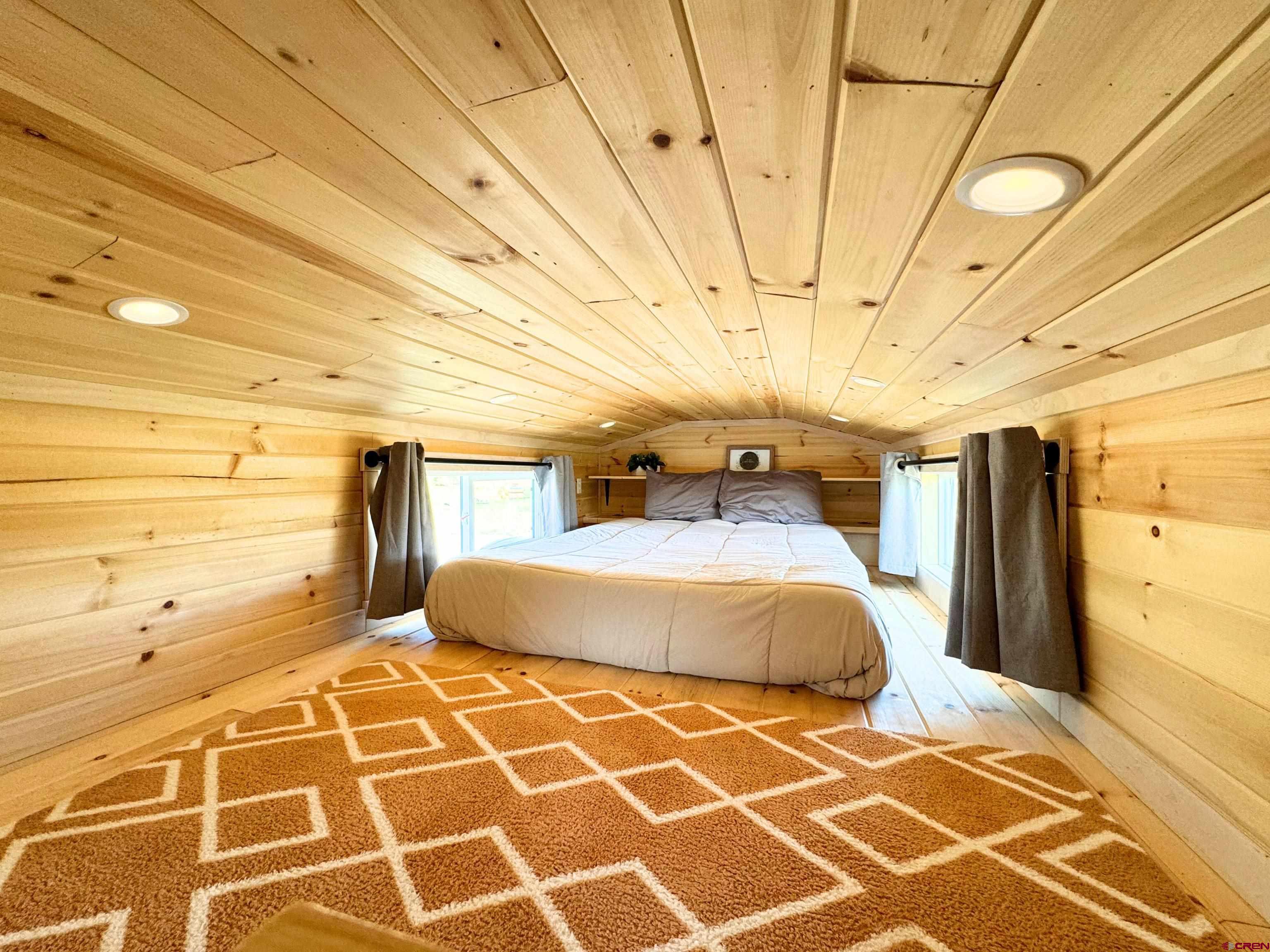 22130 6850 Road, Unit 210 Montrose, CO 81403 - Photo 19 of 35 a bedroom with a bed and wooden floor