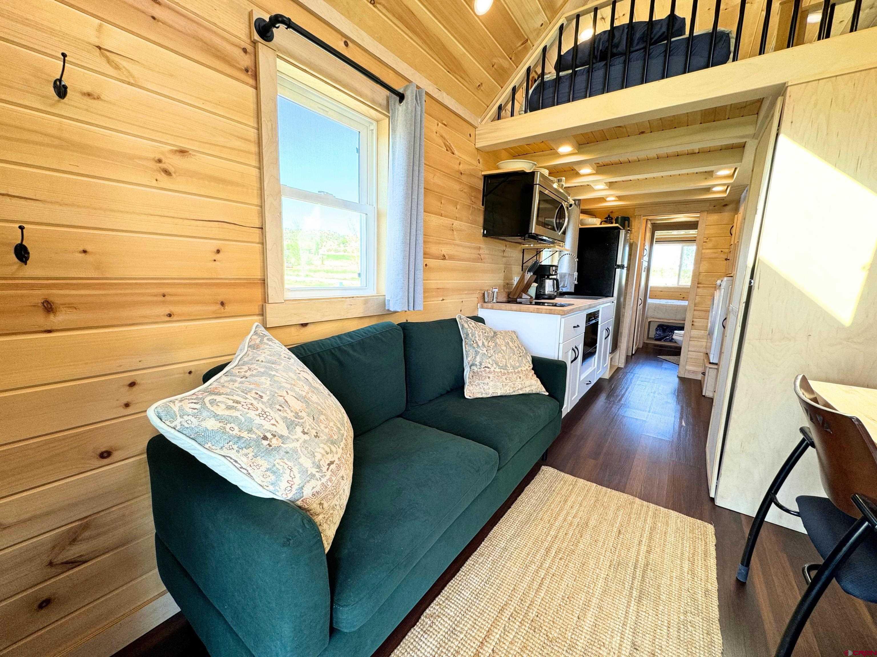 22130 6850 Road, Unit 210 Montrose, CO 81403 - Photo 2 of 35 a view of balcony with couch and wooden floor