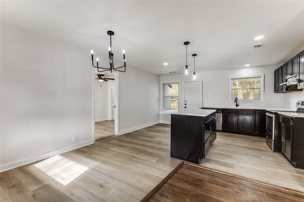 2723 Gus Thomasson Road Dallas, TX 75228 - Photo 6 of 26 a view of a kitchen with granite countertop a refrigerator and a wooden floor