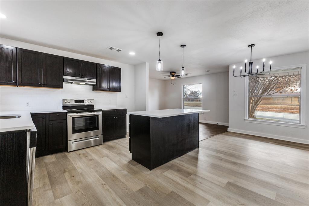 2723 Gus Thomasson Road Dallas, TX 75228 - Photo 8 of 26 a kitchen with stainless steel appliances kitchen island granite countertop a stove a sink and a refrigerator