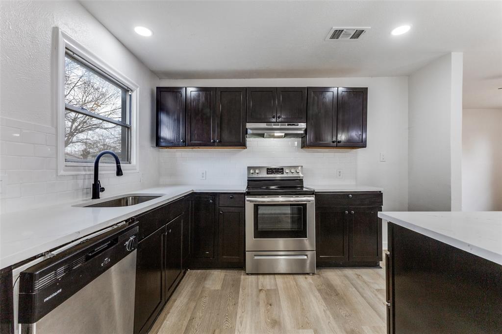 2723 Gus Thomasson Road Dallas, TX 75228 - Photo 9 of 26 a kitchen with kitchen island granite countertop stainless steel appliances and sink