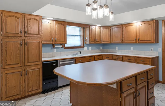 a kitchen with kitchen island granite countertop a sink window and cabinets